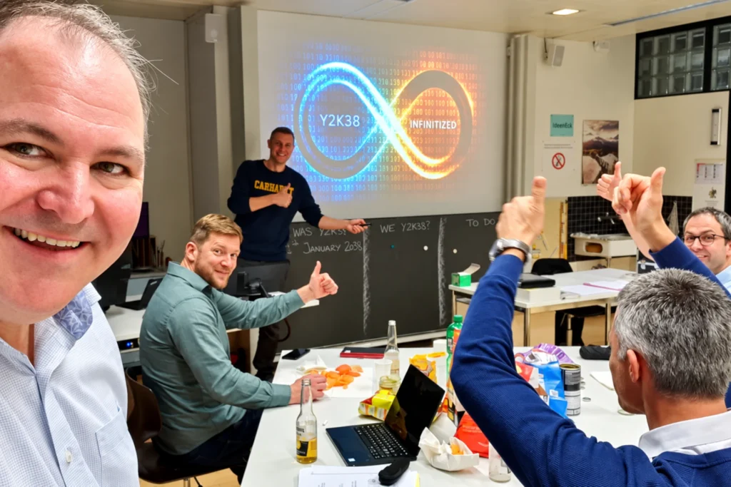 Mitglieder des MFB-Teams beim Kick-off zum Projekt «Y2K38 Infinitized» 2019. Im Hintergrund wird das blau-orangefarbene Unendlichkeitszeichen mit dem Projektnamen an die Wand projiziert.